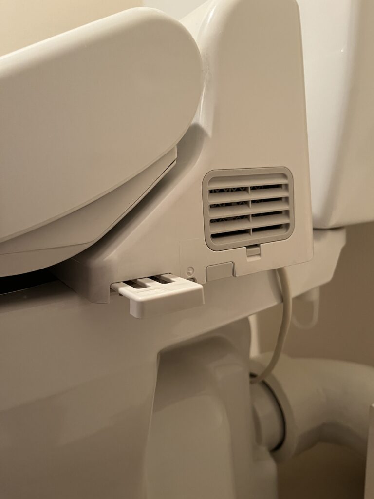 ウォシュレットの側面に付いている脱臭フィルターを取り出しているところ